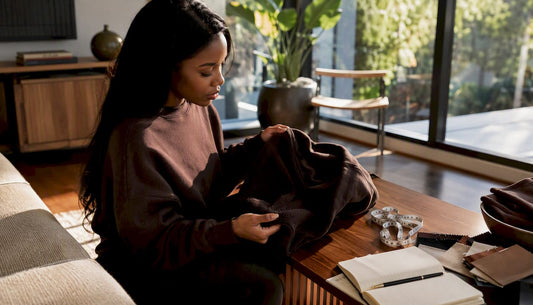 Woman examining heavyweight hoodie indoors