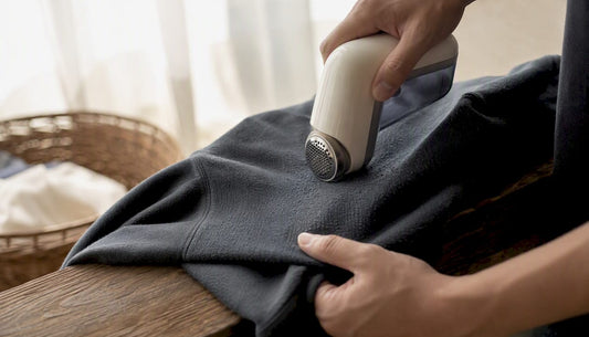 Hands shaving pilling from hoodie sleeve