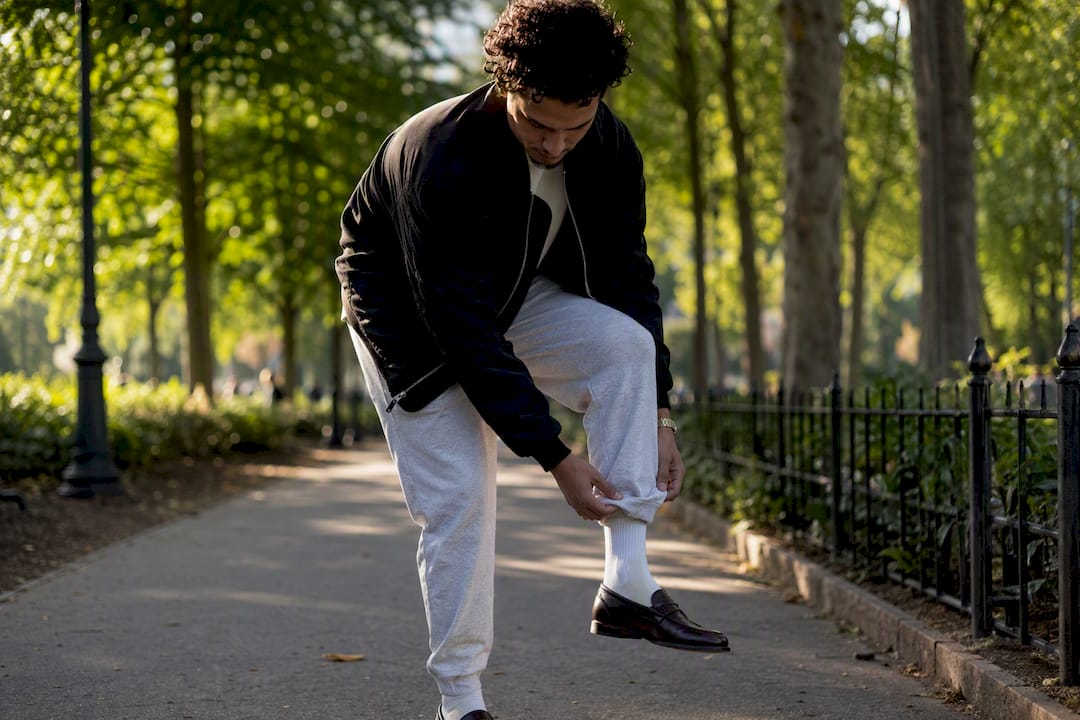 Person styling joggers with loafers and jacket
