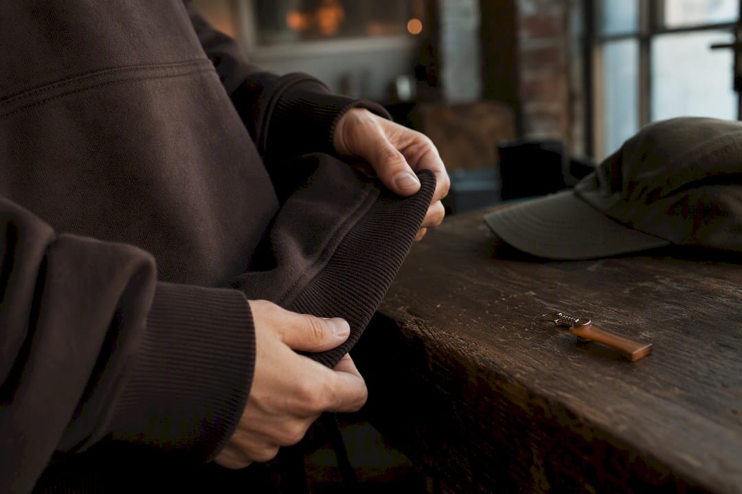 Close-up hands holding streetwear hoodie hem