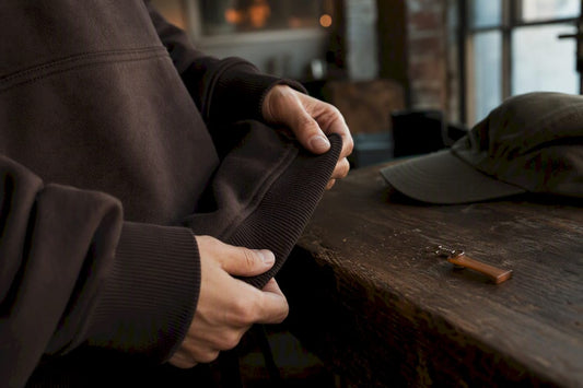 Close-up hands holding streetwear hoodie hem