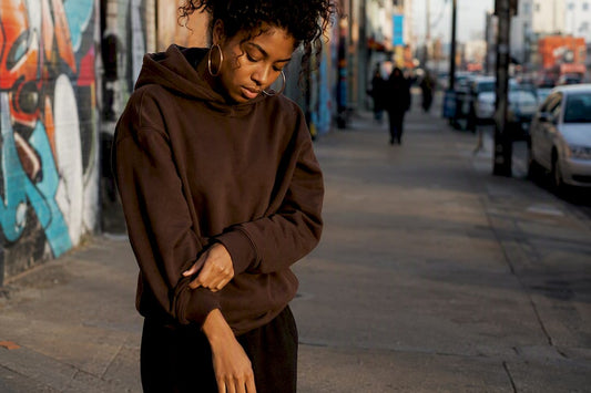 Model adjusting hoodie sleeve outdoors